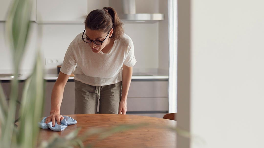 Woman cleaning table in her Airbnb